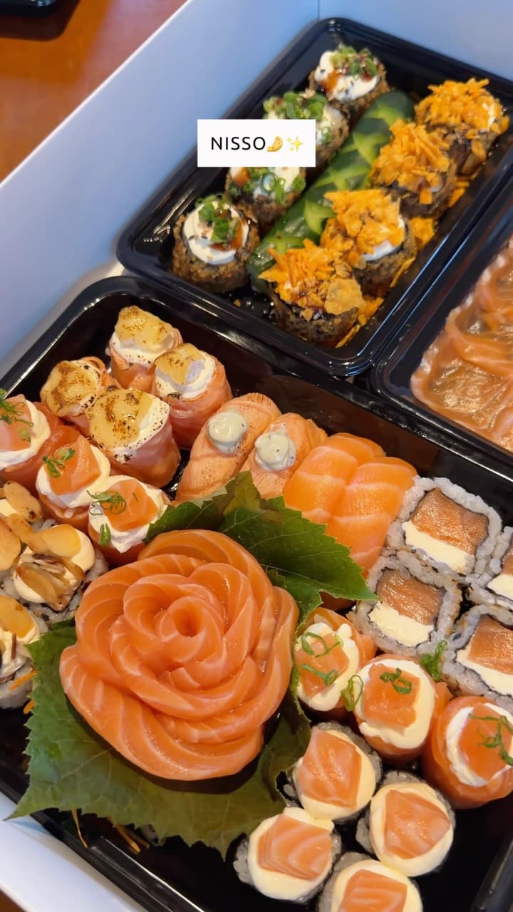 Caixa do delivery com sushis, rosa de salmão e uramakis